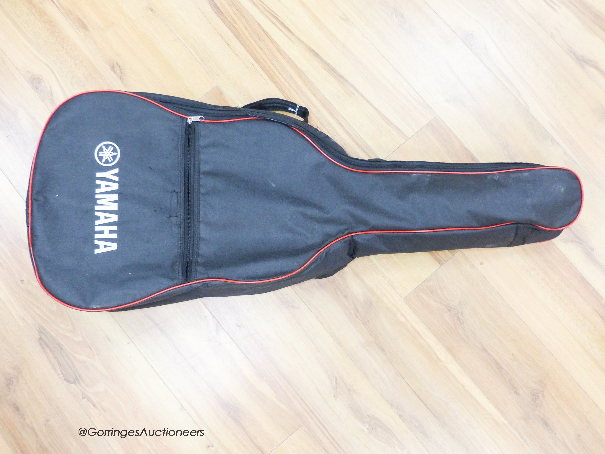 A Yamaha F310 acoustic guitar, carry case